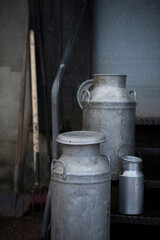 Different sizes of traditional milk churns on a Devon farm, UK.