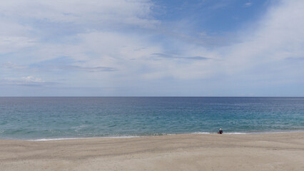 Plage du Limone, Corsica. Idyllic deserted beach , Plage du Limone in Corsica. Blue sky appearing through an overcast sky with a calm mediterranean sea.