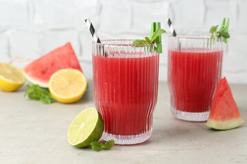 Delicious watermelon drink in glasses and fresh fruits on light table