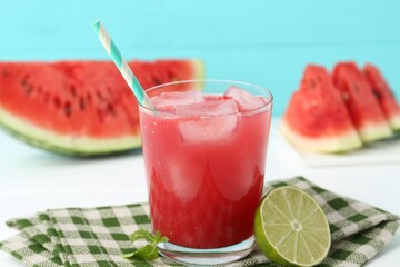 Tasty watermelon drink in glass, fresh fruits and mint on white table, closeup