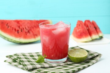 Tasty watermelon drink in glass, fresh fruits and mint on white table
