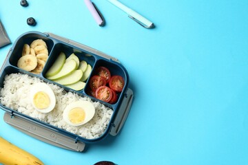 Lunch box with snacks and pens on light blue background, flat lay. Space for text