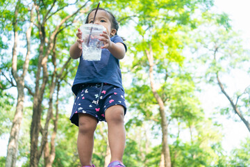 Obraz premium Portrait of happy asian toddler girl walking in city public tree park