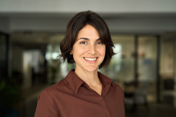 Headshot close up face portrait of young happy smiling Hispanic businesswoman, female company...