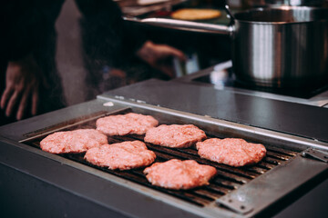 Grilling meat patties for classic burger in a cafe of a restaurant.