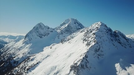 Obraz premium Breathtaking Aerial View of Snowy Mountain Range Against Bright Blue Sky