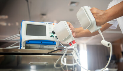 A life-saving medical device with metal paddles and electrical cords, used to restore a normal...