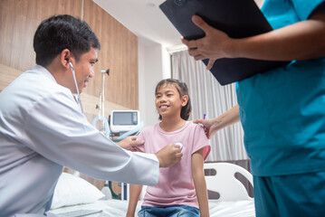 Obraz premium A team of doctors and nurses are working to treat a female patient in the patient's room.