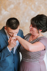 A man kisses a woman's hand. The woman is wearing a purple dress