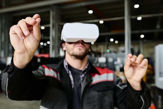 Caucasian man wearing VR headset in factory setting, engaged with virtual elements