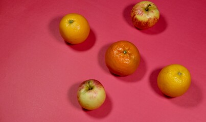 fresh apple, orange and malta on red background 