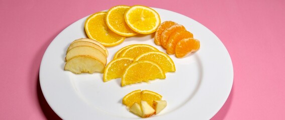 summer fresh fruits slice decorated on white ceramic plate with pink background 