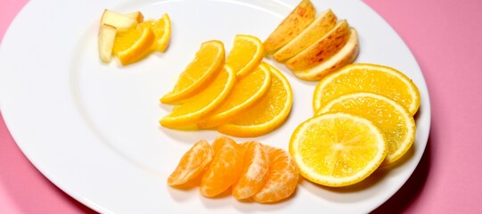 organic fresh orange, apple, malta decorated on white ceramic plate with close shot 