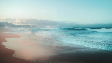 Obraz premium A serene seascape capturing gentle waves and a tranquil shoreline under a soft, pastel sky at dawn.
