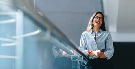 Empowered female professional smiling as she stands in an office