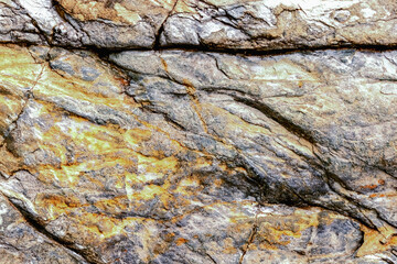 Old stone background with dark cracks, great for your design and texture background. Copy space.
