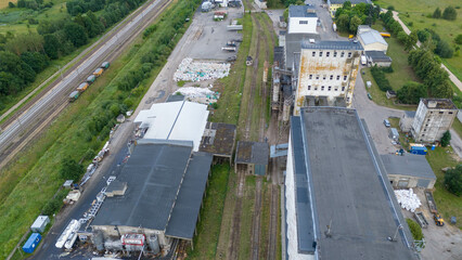 Drone photography of grain silo and factory near a railroad during summer day