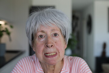 Senior woman showing her lower teeth