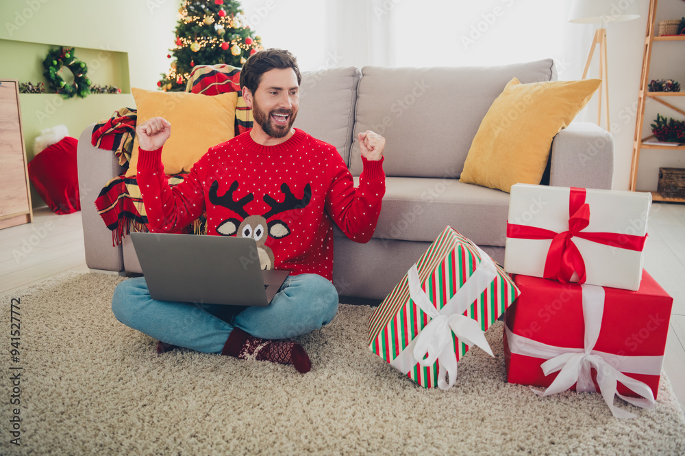 Poster full size photo of nice young man laptop raise fists giftbox ugly sweater christmas atmosphere apart