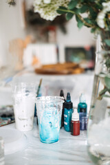 Creating colorful epoxy resin art during a DIY workshop with vibrant supplies and a floral backdrop