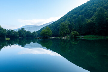 Fototapeta premium Lac de Bethmale - Pyrénées - Ariège - Tranquil Forest Lake with Mountain Views
