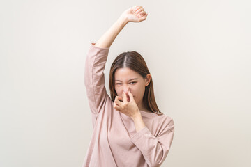 Bad smelling, deodorant asian young woman smell stink, breathing nose on armpit with underarm,...