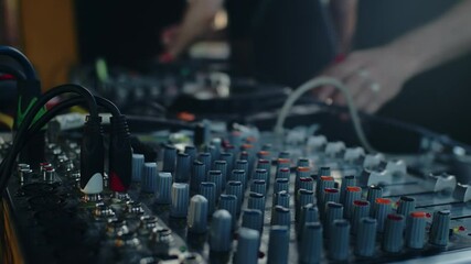 Audio engineer mixing music on analog soundboard
