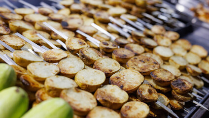 Potatoes baked on skewers. Grilled potatoes.