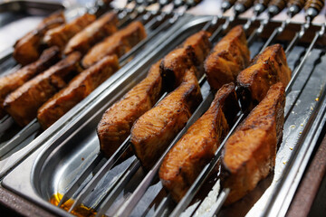 Salmon baked on skewers. Baked red fish.