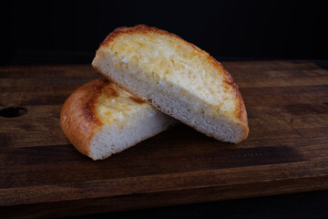 Khachapuri. Bun with cheese on a wooden background.