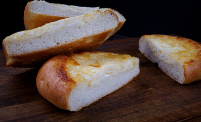 Khachapuri. Bun with cheese on a wooden background. Cheese pie.