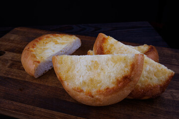 Khachapuri. Bun with cheese on a wooden background. Cheese pie.