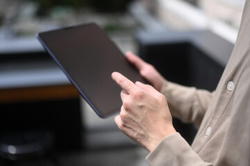 Close-up of a person using a tablet, focusing on the hands interacting with the screen, Hands-On Digital Engagement