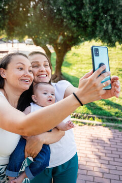 Lesbian couple with their son enjoying a selfie outdoors