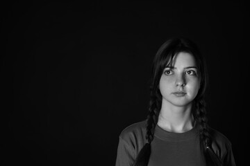 Portrait of teenage girl on dark background, space for text. Black and white effect