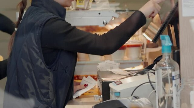 Cashiers are working, touching the touch screen, choosing the right products in coffee shop. worker using touchscreen cash register at cashier.