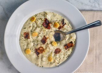 clam chowder top with bacon, parsley and crackers