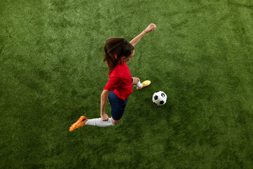 Aerial view of female soccer player preparing to hit ball in motion on green lash stadium during final game. Score goal. Concept of women and sport, team games, movement, victory, action. Ad