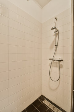 Simple white-tiled shower corner with metallic fixtures