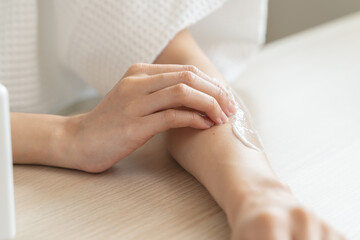 Body skin care routine concept. Close-up view hands of a young woman applying lotion cream on the shoulder