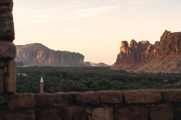 Ausblick über die Palmen Oase und die Berge und Felsen im Hintergrund dahinter bei Sonnenuntergang...