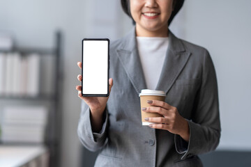 Businesswoman holding smartphone with empty screen for mobile app advertisement