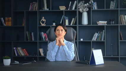 Businesswoman sitting at desk in office with © MIKHAIL