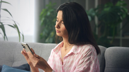 Young woman using smartphone while relaxing on