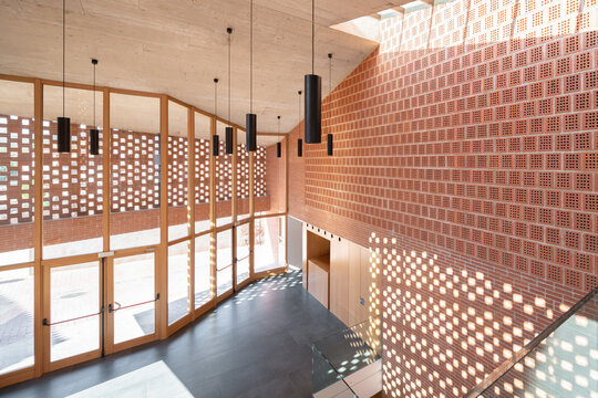 Sunlit modern auditorium hallway with patterned walls