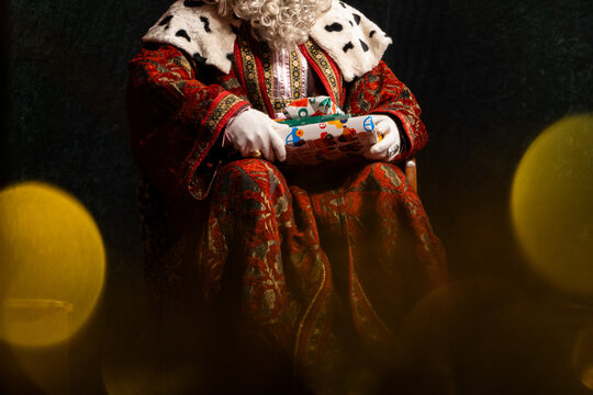 Figure of one of the wise men in traditional costume presenting a Christmas gift