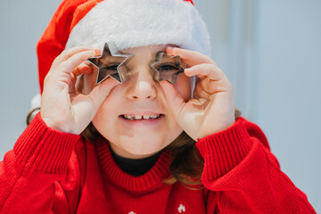 Festive girl playing with cookie cutters