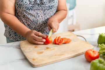 Senior adult woman preparing a meal in the kitchen.