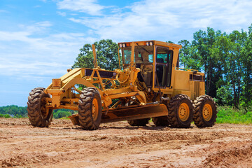 Having to work at construction site with heavy earthmoving construction grader tractor