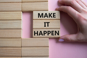Make it Happen symbol. Concept words Make it Happen on wooden blocks. Beautiful pink background....